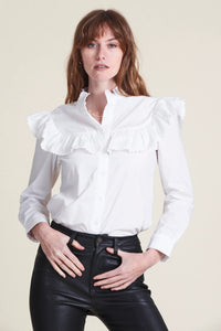 Ruffles with small ric rac trim adorn The Gwenyth Shirt.  Rochelle Behrens reimagined how shirts should fit and feel. Our patented No Gape® button technology, seamlessly designed into every shirt and shirtdress we design, eliminates blouse gape. Finally say bye bye blouse gape, hello The Shirt.  Imported Powered by our patented No Gape® button technology. Model is 5’9 wearing size S