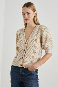  This stylish short sleeve cardigan sweater is a great way to make a statement while keeping comfortable all season long. Made from a cozy wool blend, this cardigan short sleeve sweater features braided leather buttons. 64% Wool | 17% Acrylic | 14% Polyamide | 5% Polyester.